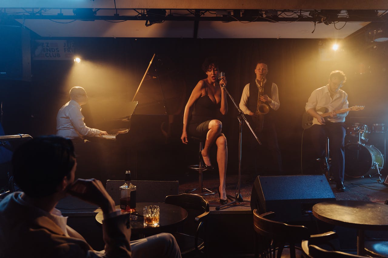 A jazz band performing live in a dimly lit nightclub, featuring a singer and various musicians.